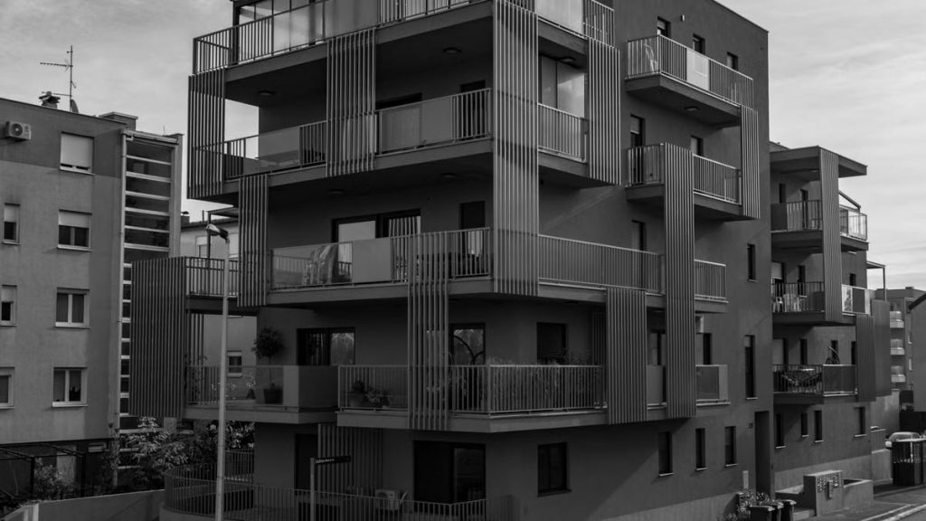 Grayscale photo of a modern residential building in Zagreb with balconies.
